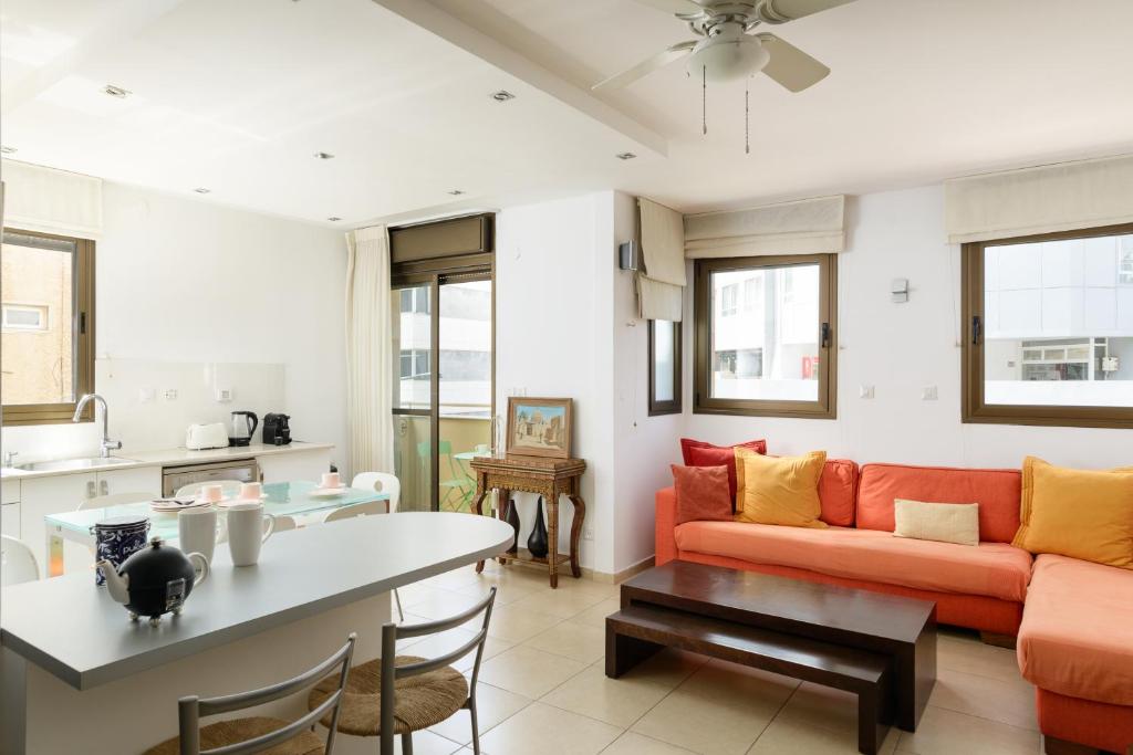 ein Wohnzimmer mit einem Sofa und einem Tisch in der Unterkunft Cosy 1BR near Beach by FeelHome in Tel Aviv