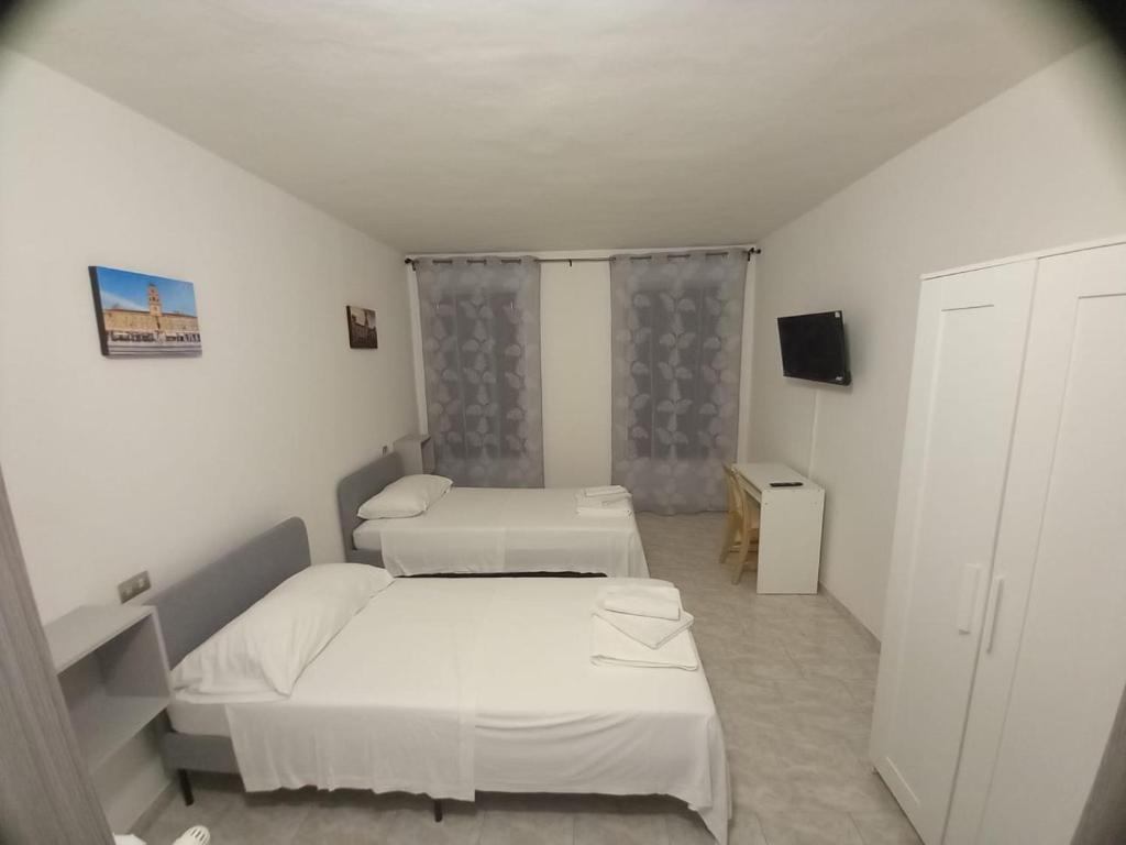 Zimmer mit 2 Betten und einem TV. in der Unterkunft Residenze Amelia in Parma