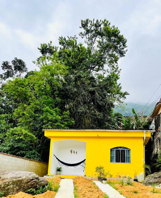 una casa amarilla con una sonrisa pintada en ella en Carvalho de Muriqui en Mangaratiba