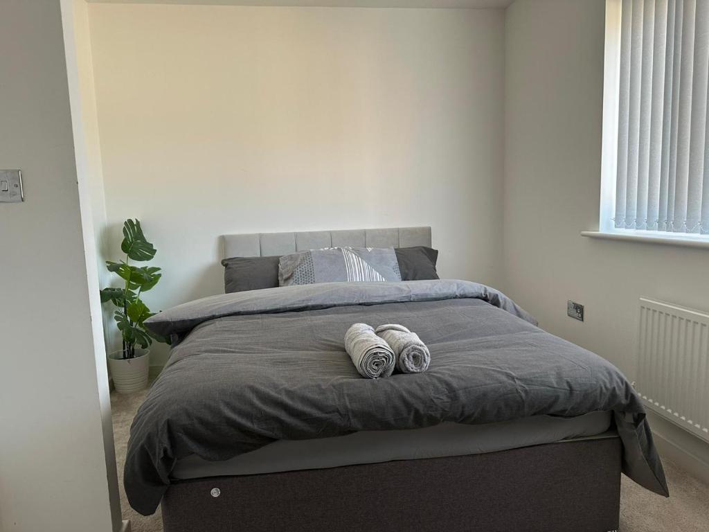 a bedroom with a bed with two pillows on it at Luxury Rooms in a 3-Bedroom House, Living Room, Kitchen, Big garden only 8mins away from Coventry City Centre in Coventry