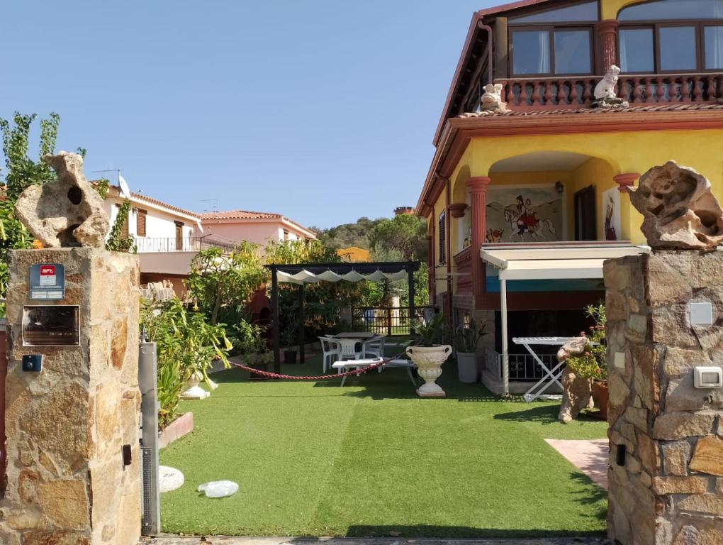 une maison avec une cour avec de l'herbe verte dans l'établissement Casa Pietro, à San Teodoro