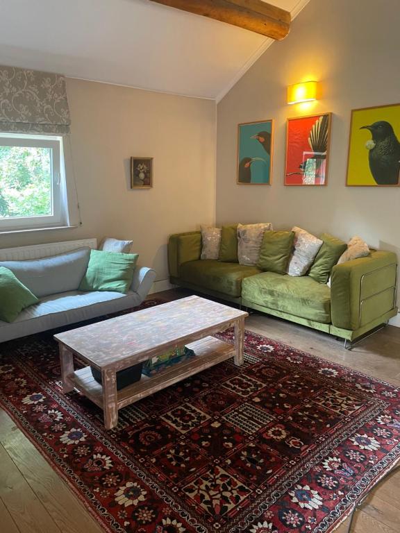 a living room with a couch and a coffee table at La Bruyere du Coq Stables in Sart-Dames-Avelines