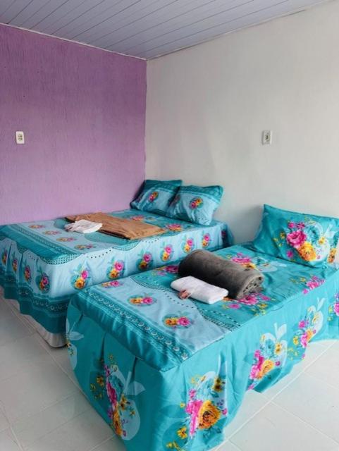 um quarto com uma cama e uma cama individual com lençóis azuis em Hostel das Flores em Belém