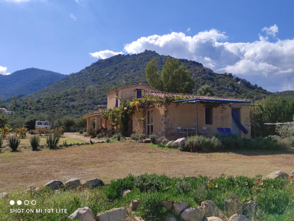 an old house with a mountain in the background at Appartamento a Feraxi in Muravera