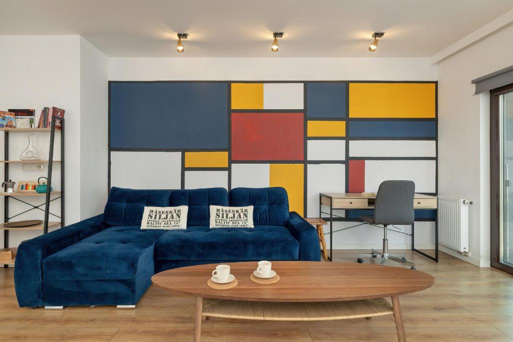een woonkamer met een blauwe bank en een tafel bij Solna Cracow Air-conditioned Apartment with Balcony by Renters in Krakau