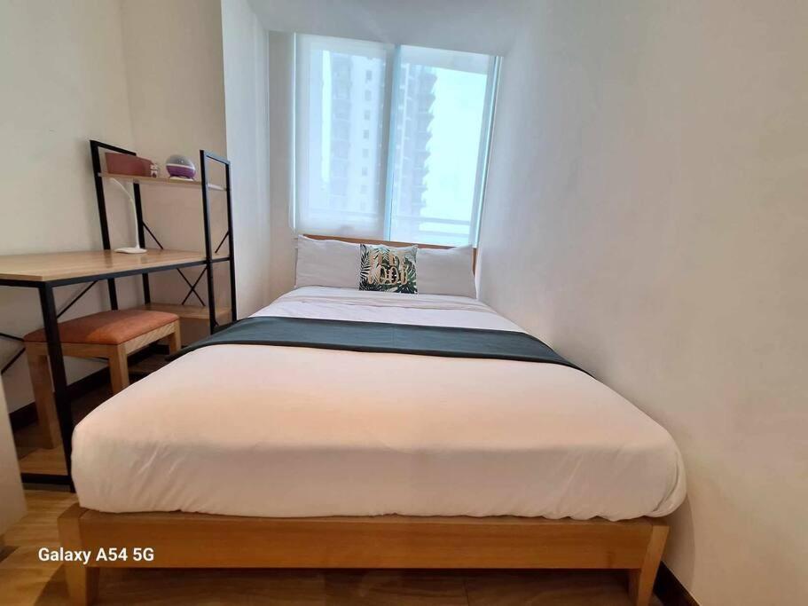 Cama pequeña en habitación con ventana en Resort Living 2BR Azure Urban Residences w/ Wi-Fi en Parañaque
