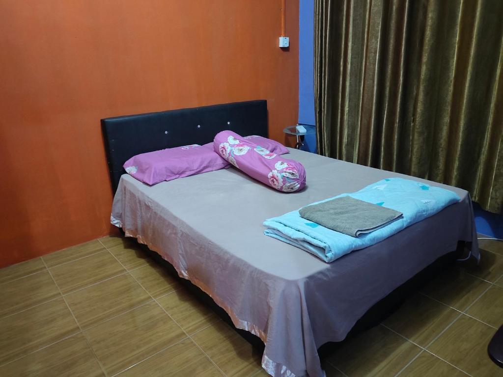 a bed with two pillows and towels on it at Home Sweet Home in Kuching