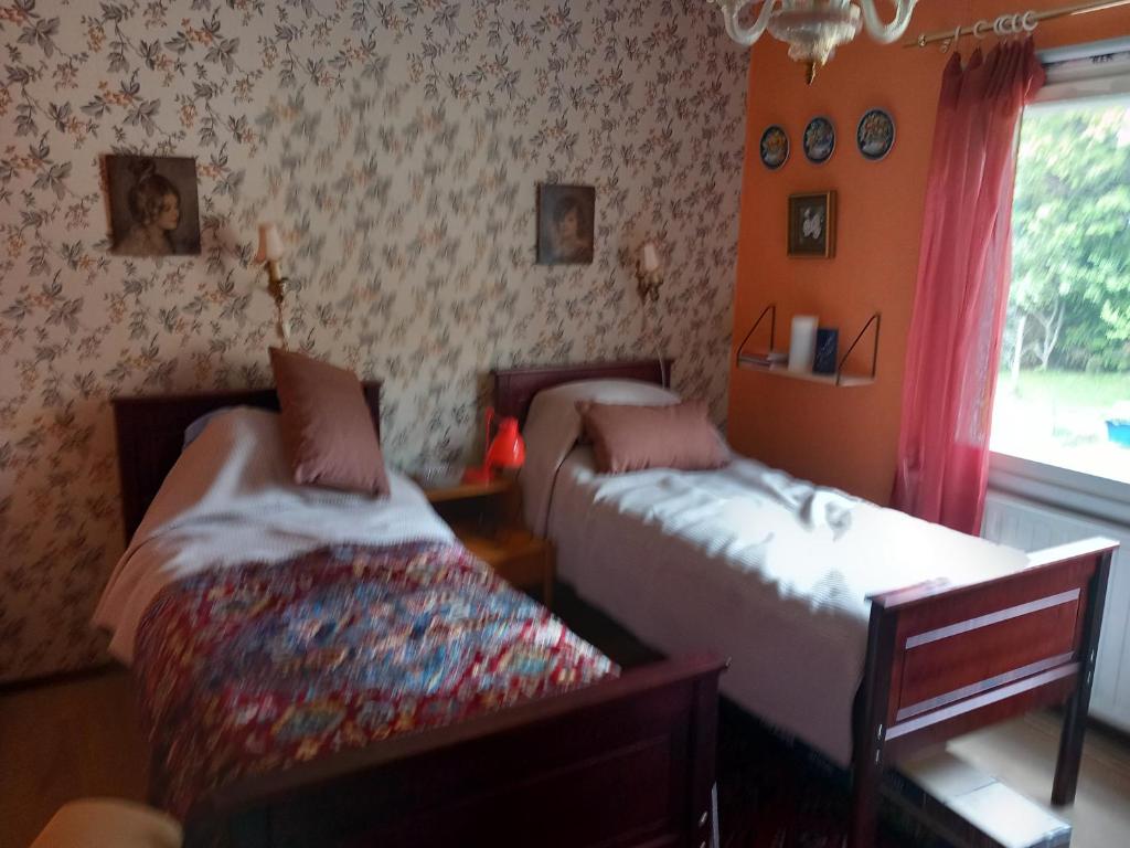 a bedroom with two beds and a window at Vaskio-bed in Salo