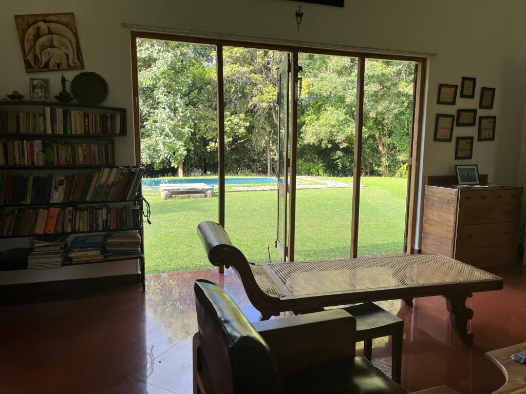 a living room with a table and a book shelf at Rivendell Twisted Tree in Kurunegala