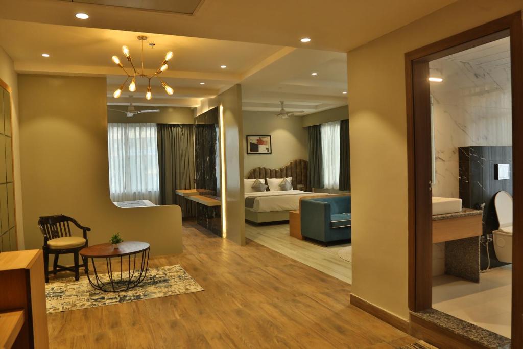 a living room with a bed and a dining room at Hotel Westend in Udaipur