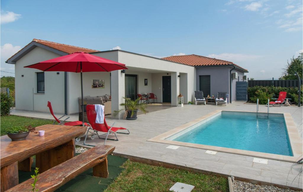 ein Haus mit einem Pool und einem roten Regenschirm in der Unterkunft Nice Home In Barban With Outdoor Swimming Pool in Barban