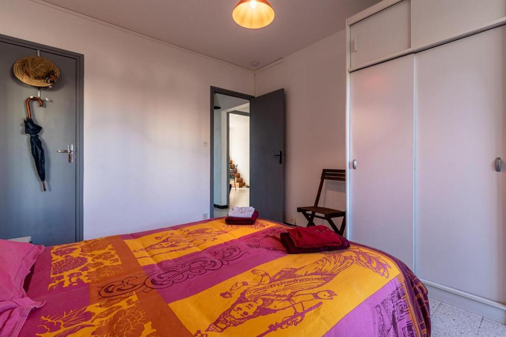 - une chambre avec un lit et une couverture colorée dans l'établissement Bel Orizonte, Grand appart 70m2 vue mer, à Ajaccio