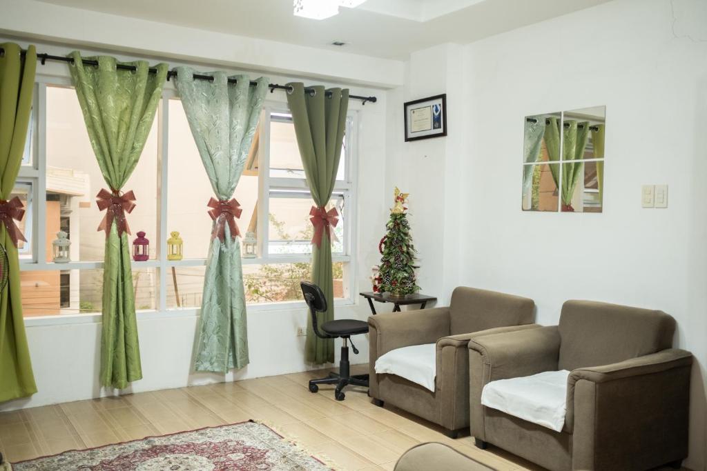 uma sala de espera com duas cadeiras e uma árvore de Natal em The Greens Home & Garden - ENTIRE 3RD FLOOR em Baguio