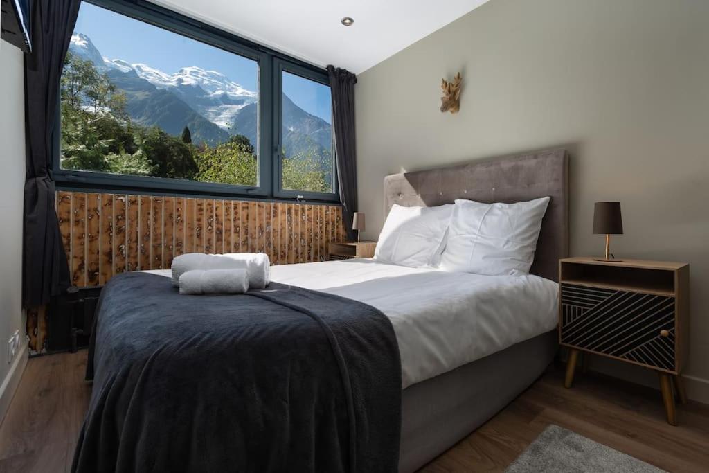 ein Schlafzimmer mit einem Bett und einem großen Fenster in der Unterkunft Modern apartment with the best Mont Blanc view! in Chamonix-Mont-Blanc