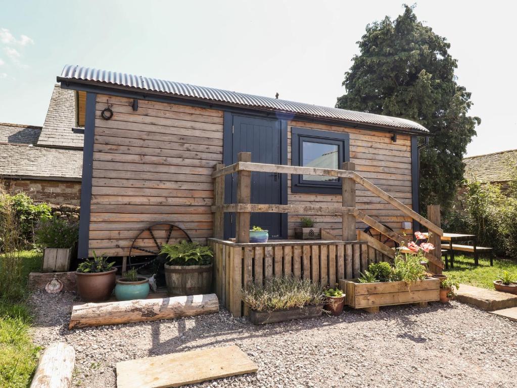 a tiny house with a fence and some plants at Dunfell Shepherd's Hut in Dufton