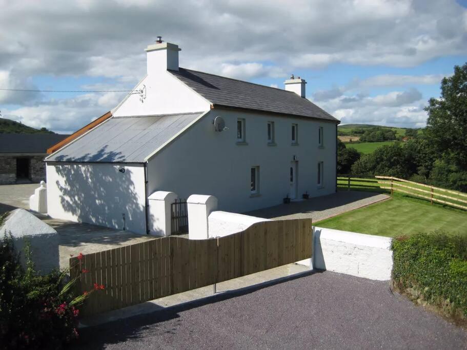 un edificio bianco con una recinzione di fronte di Babeann's at Kilmeen Wood Farm, West Cork a Clonakilty