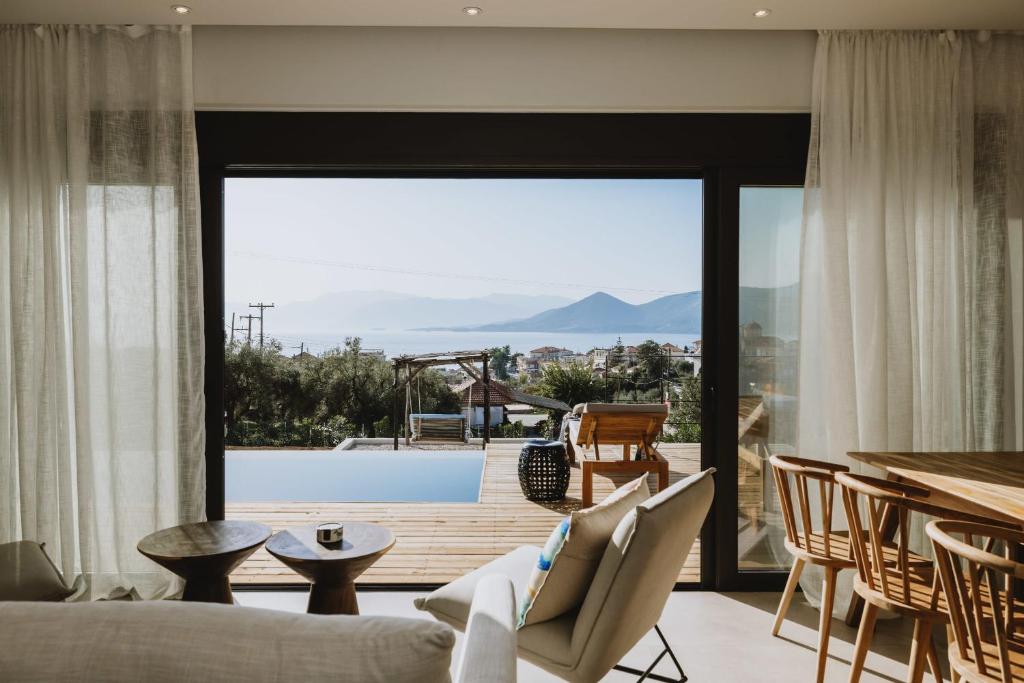 a living room with a view of a pool at Villa Morby in Paleros