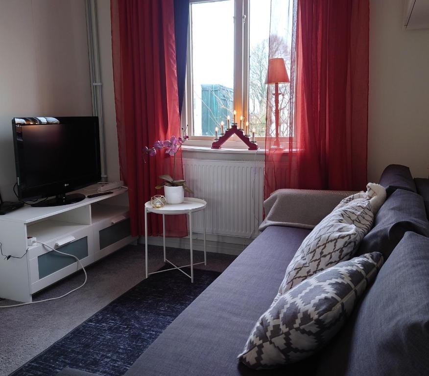 a living room with a couch and a television at Lyckans Lodge in Dösjebro