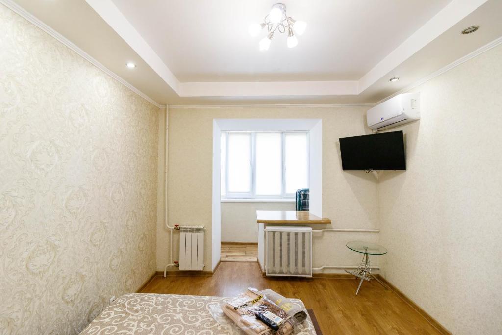 a room with a bed and a tv on a wall at Kvartirkoff na Polku Azov 32b in Kyiv