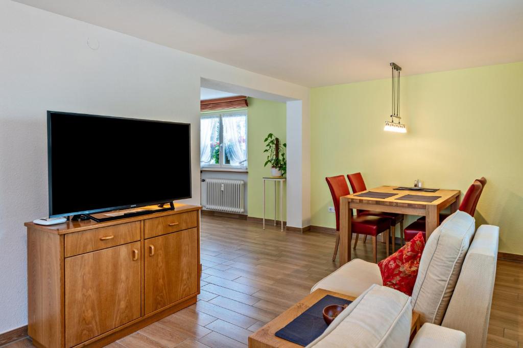 a living room with a flat screen tv and a table at Ferienwohnung Haus Irma in Höchenschwand