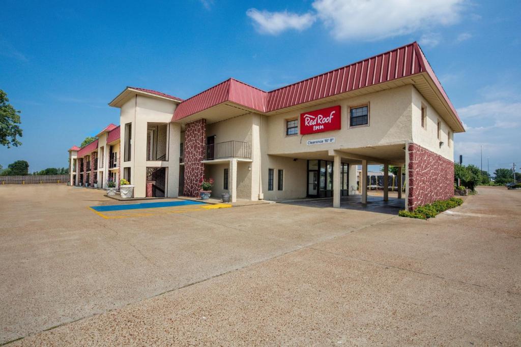 a large building with a red roof at Red Roof Inn Forrest City in Forrest City