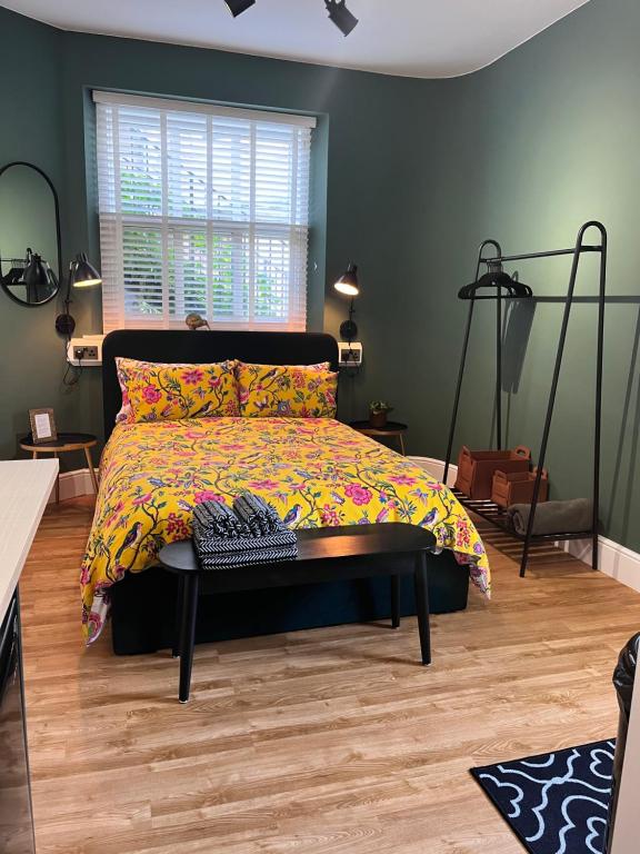 ein Schlafzimmer mit einem Bett mit einer farbenfrohen Tagesdecke in der Unterkunft The Boot Room Ground Floor Studio Apartment in Burnham on Crouch