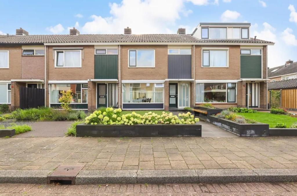um edifício de apartamentos com um jardim em frente em Apeldoorn- ruime eengezinswoning met 5 slaapkamers em Apeldoorn