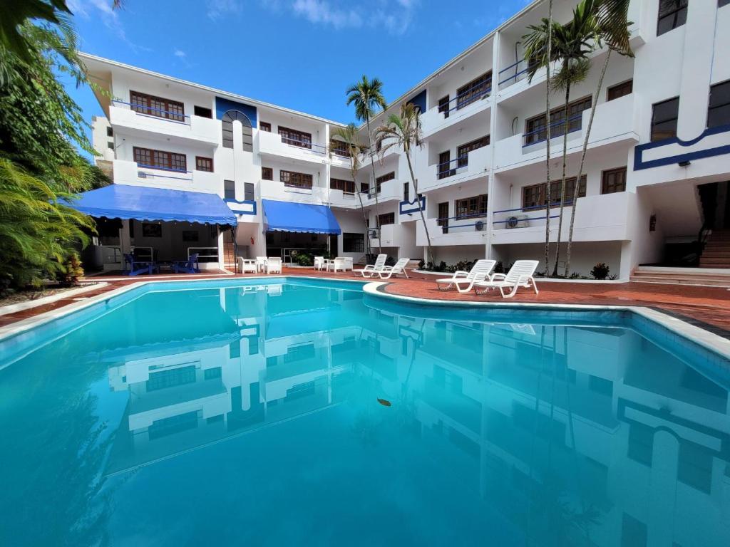 a swimming pool in front of a building at Calypso Beach Hotel by The Urbn House Santo Domingo Airport in Boca Chica