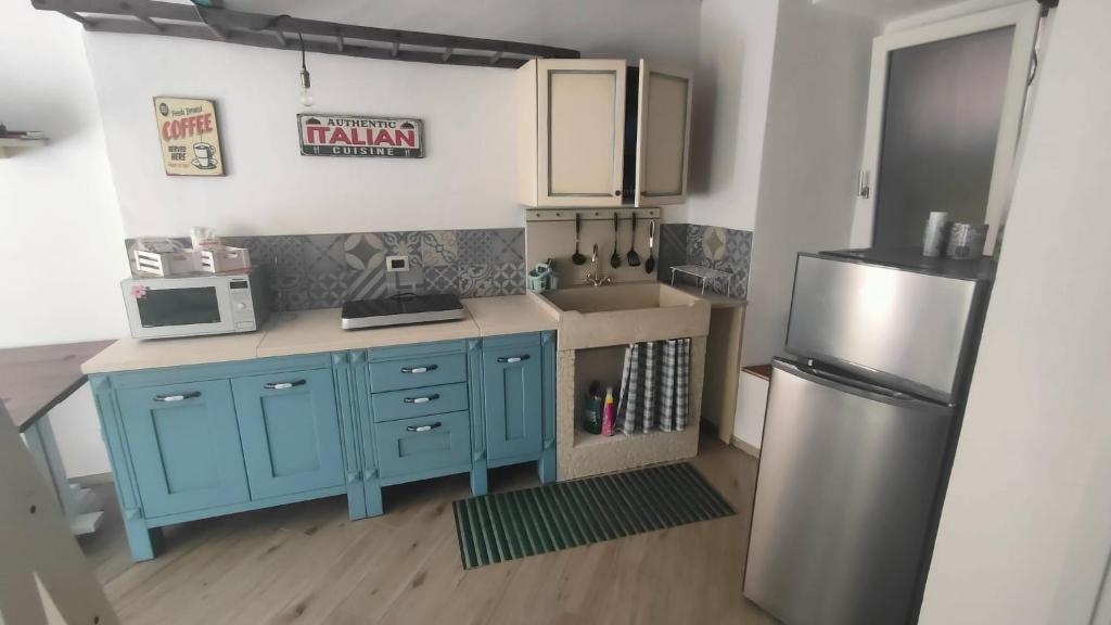 una cucina con armadi blu e frigorifero di Appartamento Vecchia Bottega a Orino