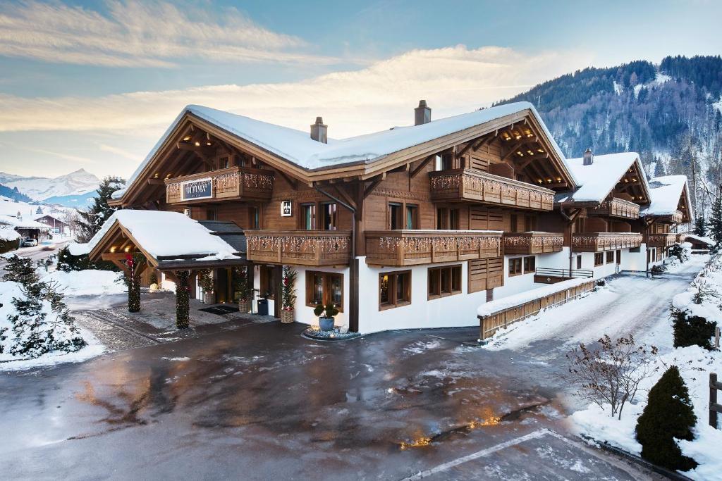 a large wooden house with snow on the ground at Ultima Gstaad Residences in Gstaad