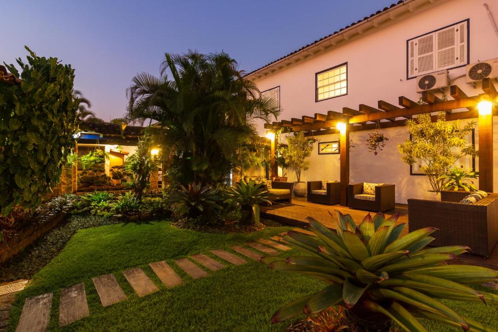 a garden in front of a house at night at Pousada Aconchego in Paraty