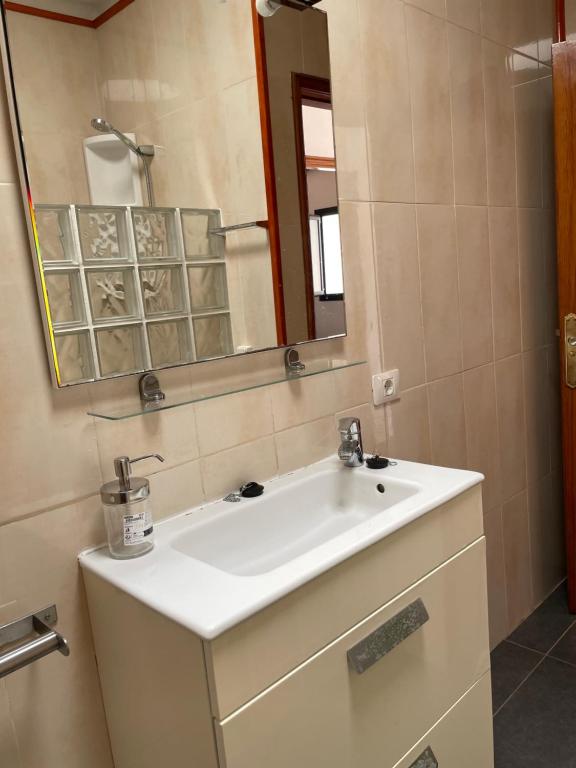 a bathroom with a white sink and a mirror at Apartamento con amplia terraza en la playa in Puerto del Carmen
