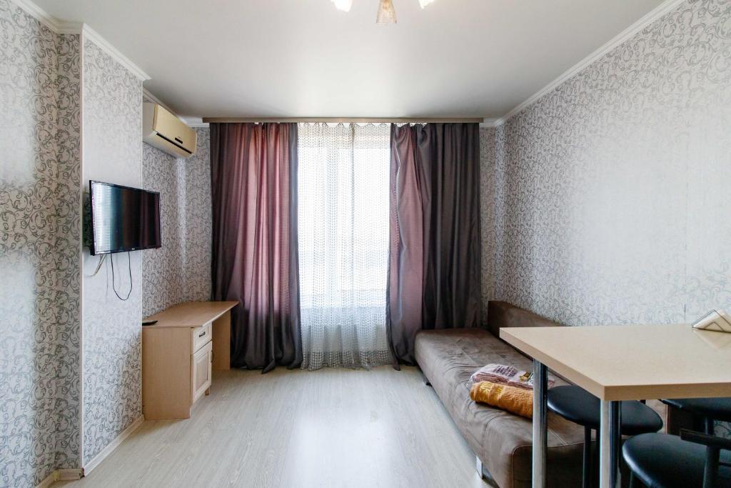 um pequeno quarto com um sofá e uma janela em Kvartirkoff na Bogatirskaya 6a, 10 floor em Kiev
