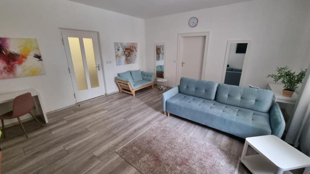 a living room with a blue couch and a table at Apartman Centrum Mudronova in Košice