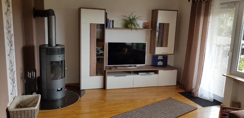 a living room with a fireplace and a television at NEU! Ferienwohnung am Schwedenberg in Elfershausen