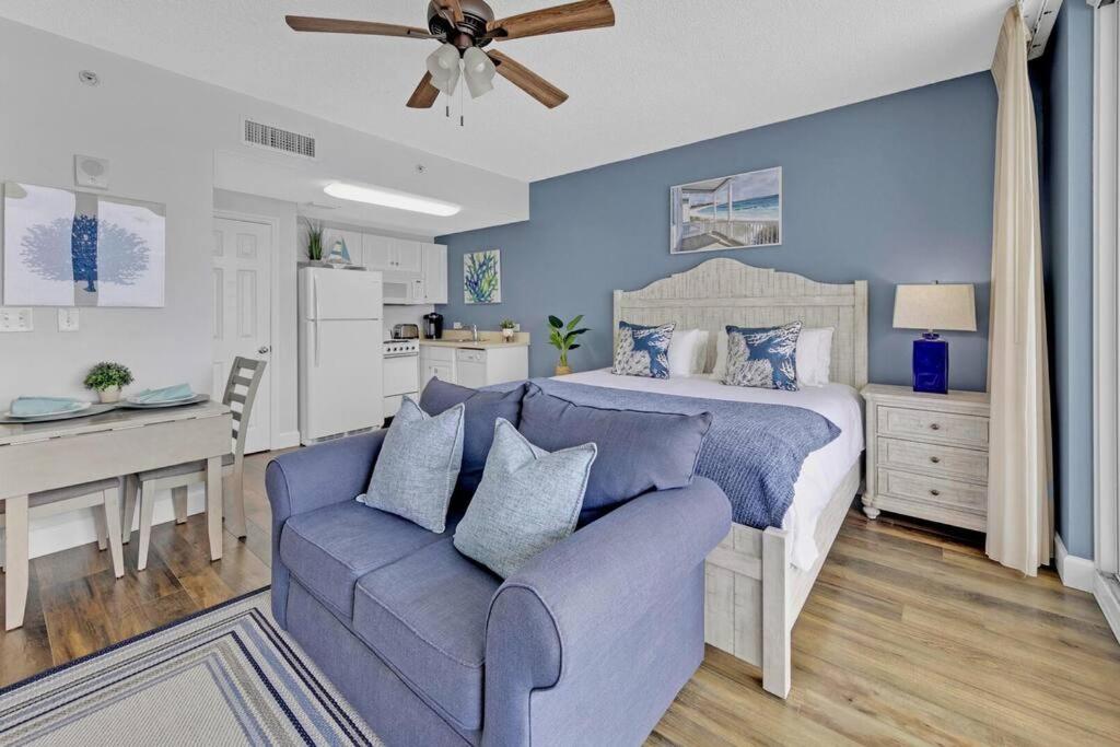 a bedroom with a bed and a couch at Beachfront Studio #909 at Majestic in Panama City Beach