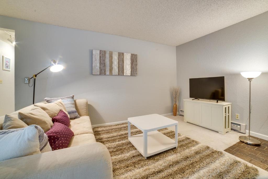 ein Wohnzimmer mit einem Sofa und einem TV in der Unterkunft Cozy Kirkland Condo about 11 Mi to Downtown Seattle! in Kirkland