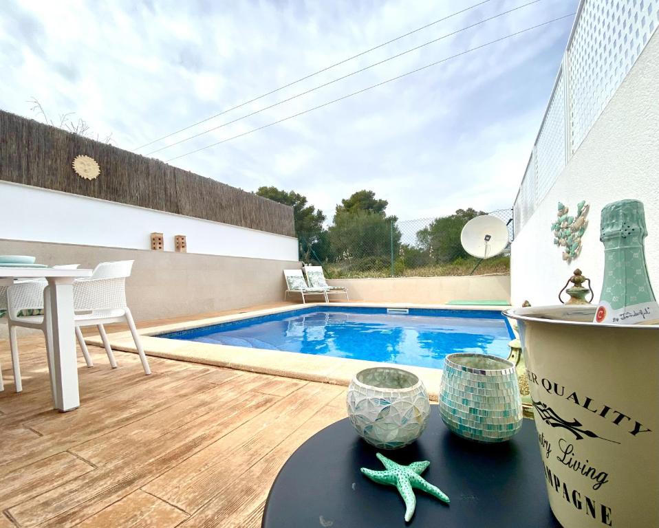 a patio with a swimming pool and a table with starfish at Stella Maris in Cala Pi