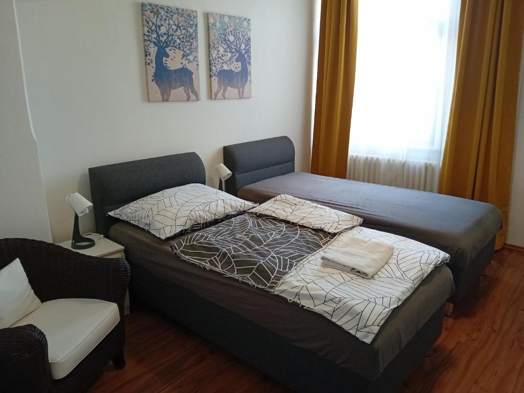 sypialnia z dwoma łóżkami i krzesłem w obiekcie Apartmány Šrámek Stříbro w mieście Stříbro