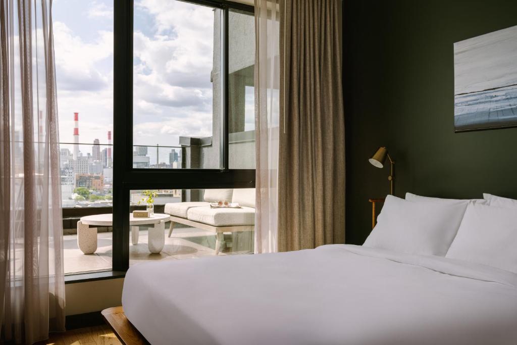 a hotel room with a bed and a large window at Sonder The Dutch in Long Island City