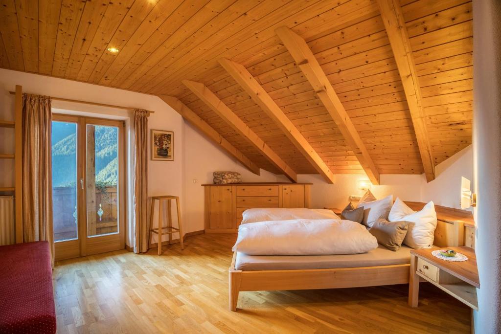 a bedroom with a bed and a wooden ceiling at Adulty Only Wasserfall Tschorn in Fundres