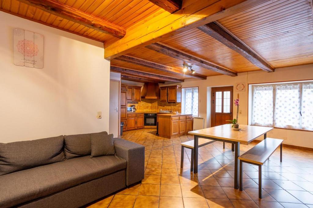 uma sala de estar com um sofá e uma mesa em Maison De Vacances 6-8 Pers Proche em La Tour-dʼAuvergne