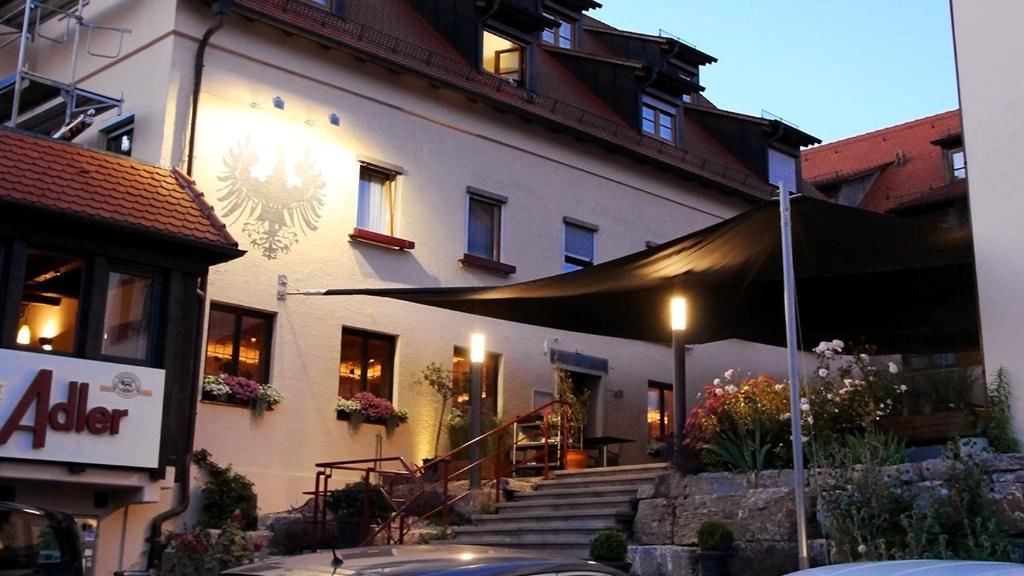 a large white building with a black umbrella outside at Hotel Gasthof Adler in Ulm