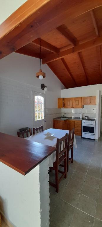Una cocina con una gran mesa y sillas de madera. en Los Choiques Madryn, en Puerto Madryn