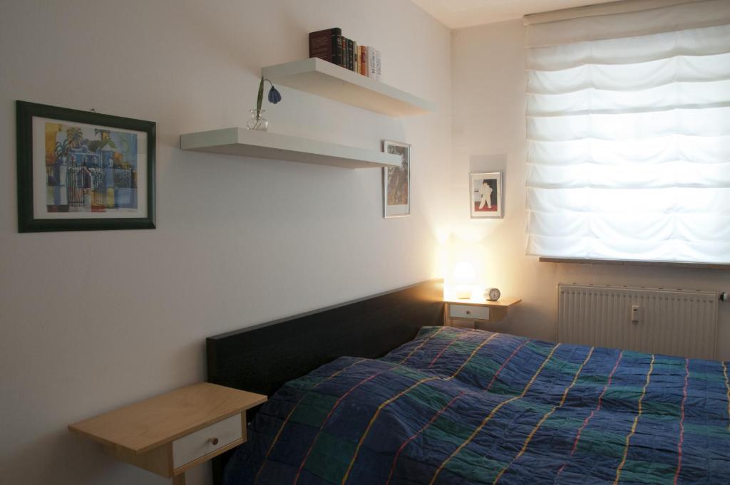 sypialnia z łóżkiem, biurkiem i oknem w obiekcie Ferienwohnung Henniger w Dreźnie