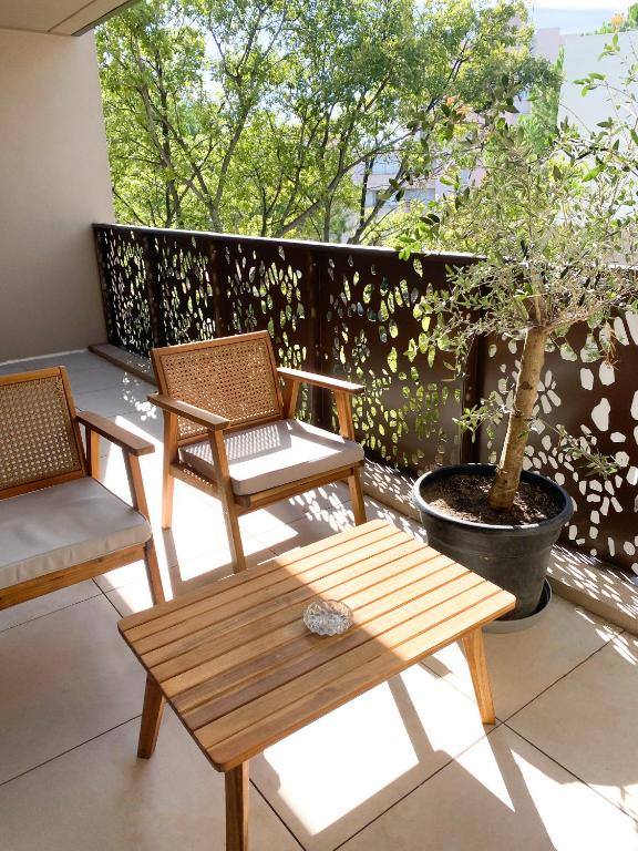 two chairs and a table on a patio with a tree at Appartement terrasse proche Centre in Montpellier