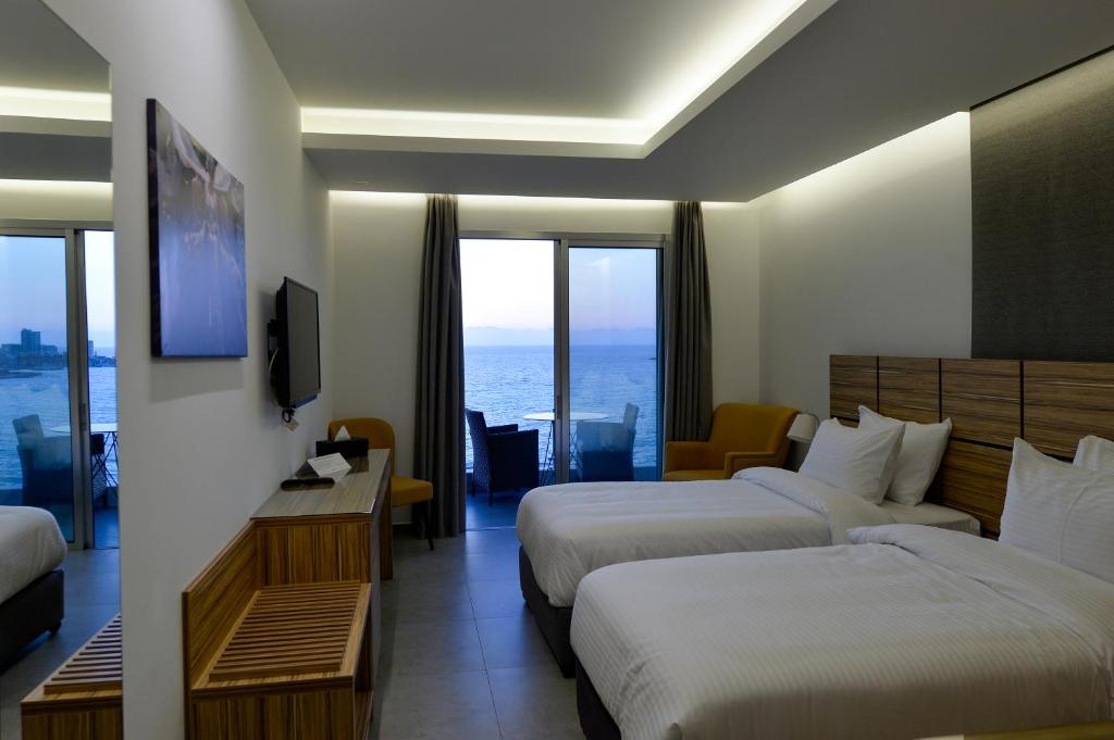 a hotel room with two beds and a view of the ocean at Zett hotel in Jounieh