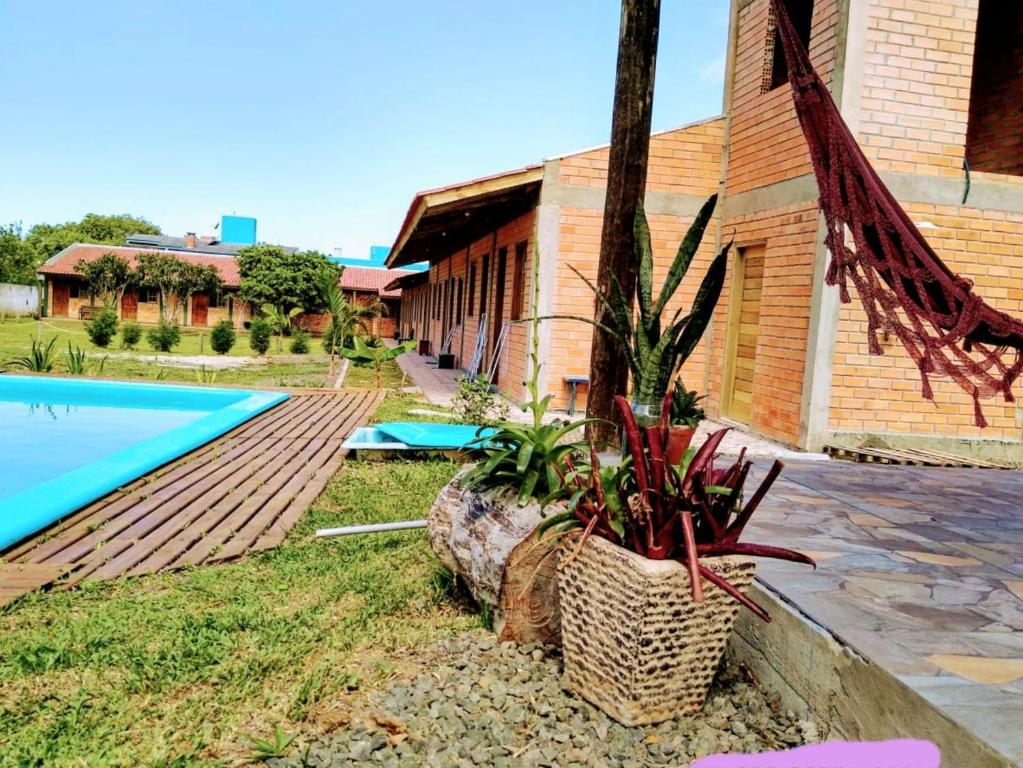une maison avec une piscine à côté d'un bâtiment dans l'établissement Pousada Angel's It, à Torres