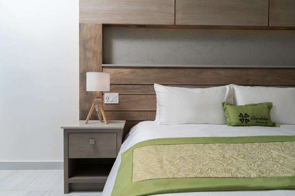 - une chambre avec un lit et une tête de lit en bois dans l'établissement Hotel Cordelia Resort & Spa, à Loreto