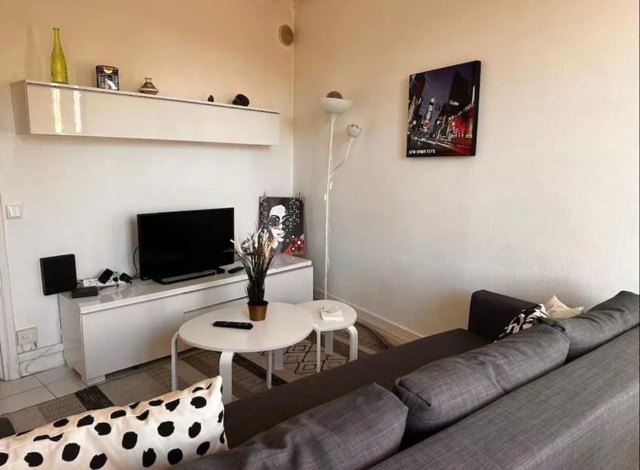 a living room with a couch and a table at Chez Marie - 4p - Proche Paris - Metro 8 in Maisons-Alfort